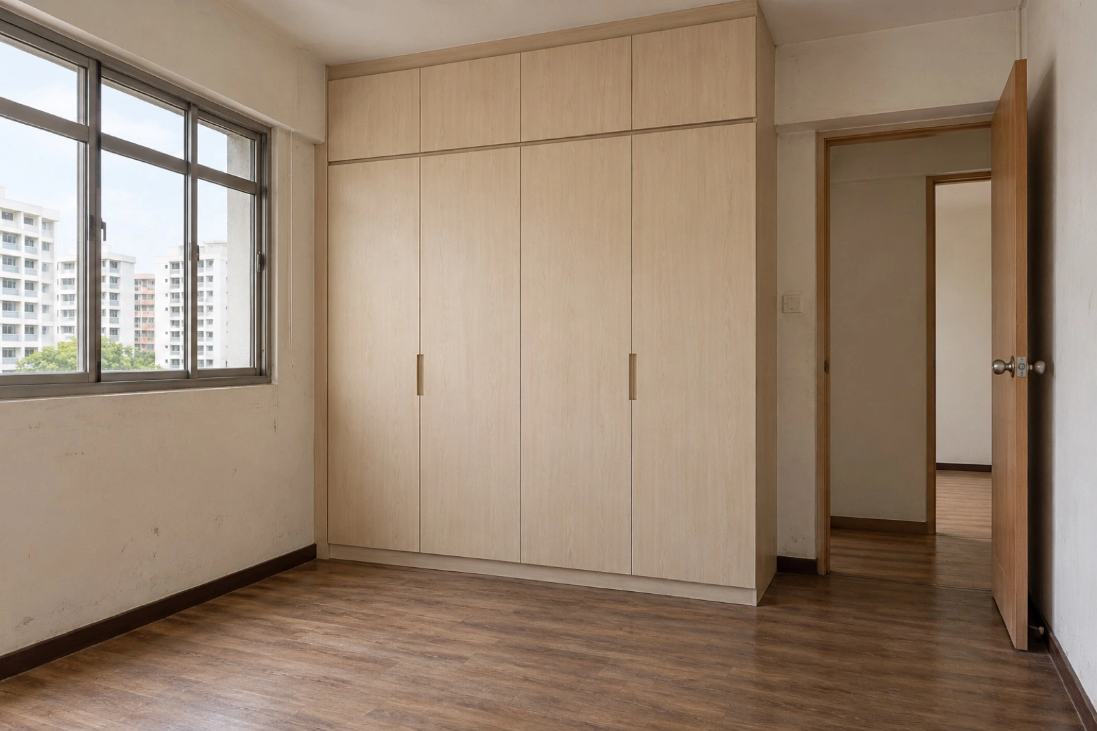Before: Empty bedroom with retained pale timber wardrobe and timber-look vinyl floor. After: Celadon bedroom with pale linen bed, keeping the original wardrobe and floor.